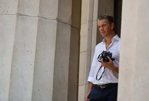 Markus Lanz mit Fotoapparat zwischen Säulen